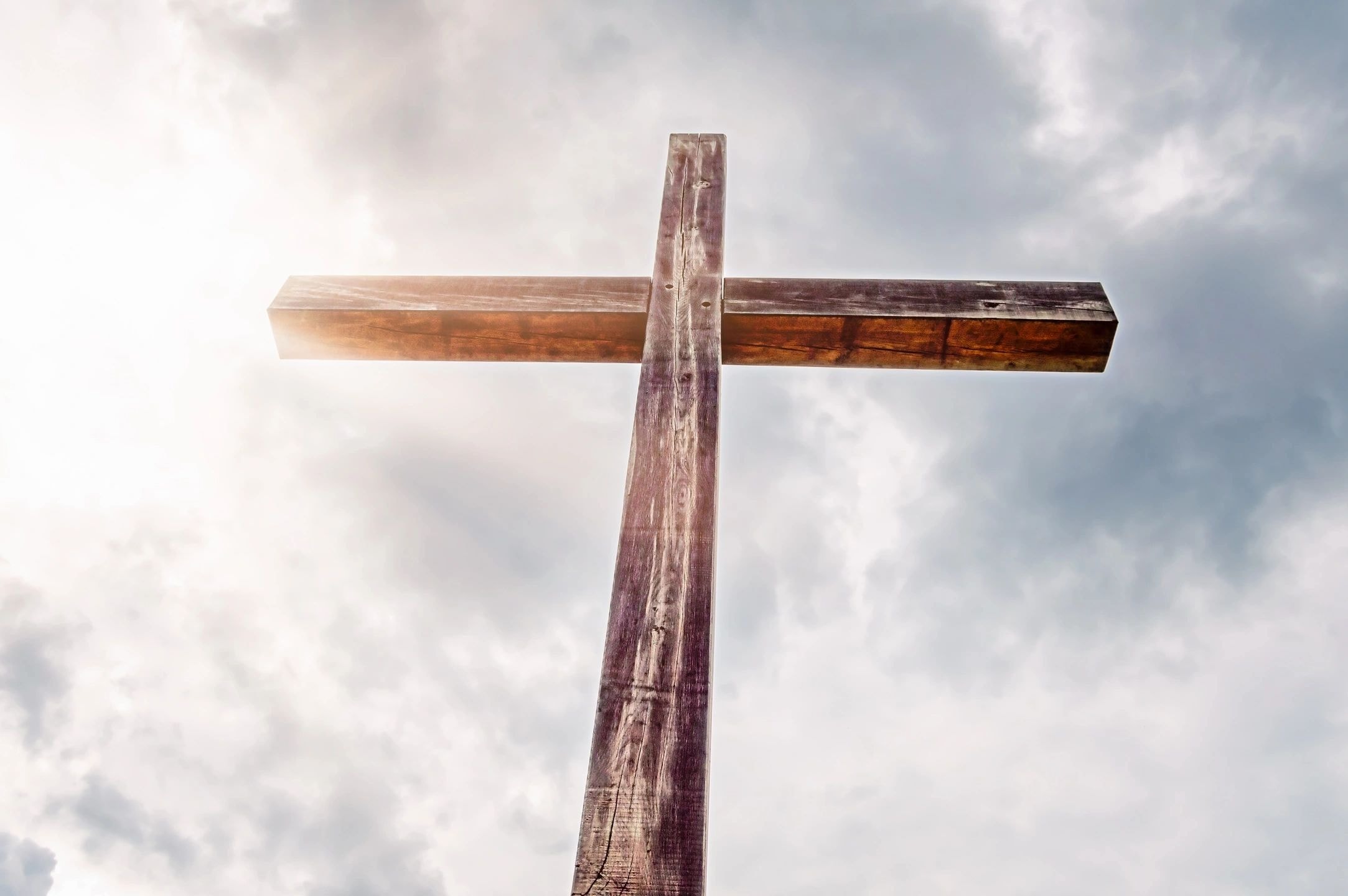 Wooden cross against cloudy sky
